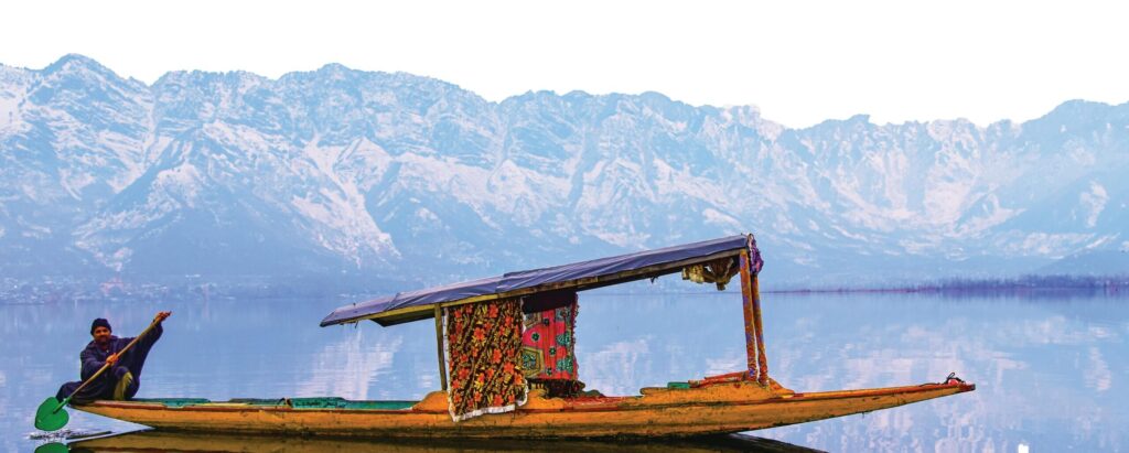 A vibrant shikara on Dal Lake with the stunning Himalayan backdrop, perfect for travel exploration.